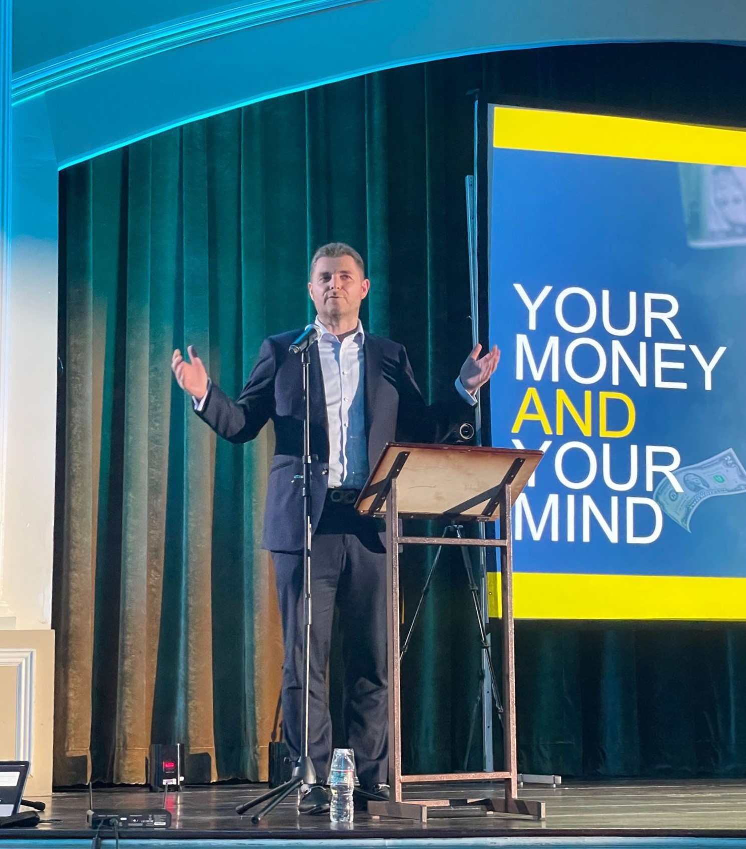 Shmuel Shayowitz speaking on stage about money and mindset